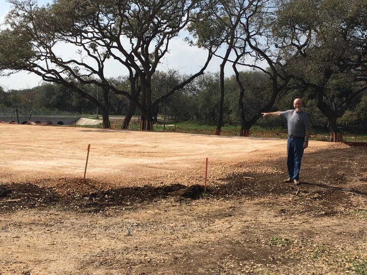 a man standing on a dry grass field