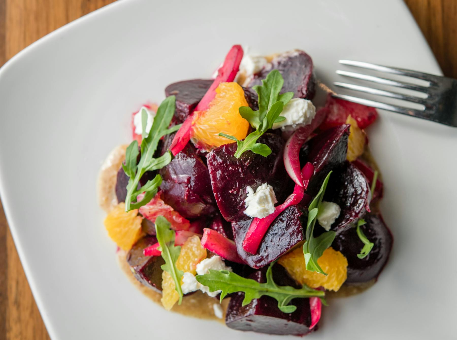 a white plate topped with a salad and a fork