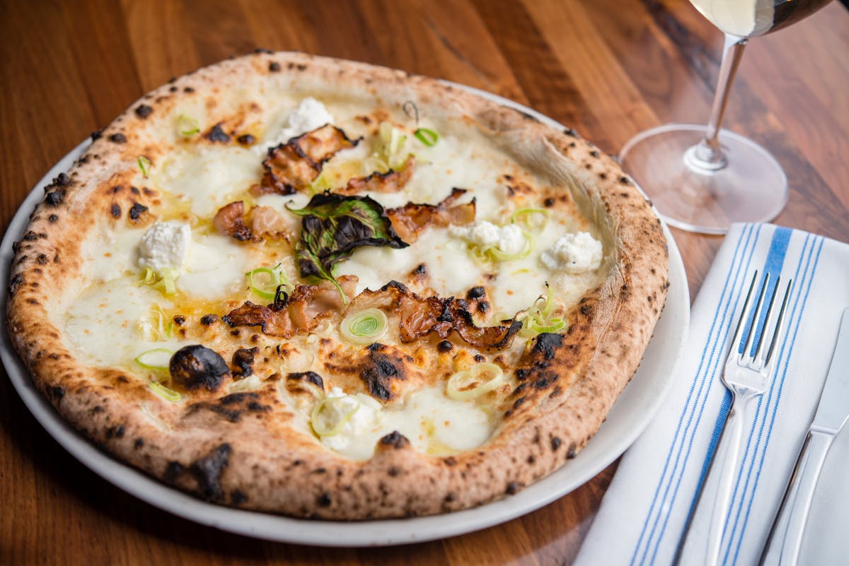 a plate of pizza sitting on top of a wooden table