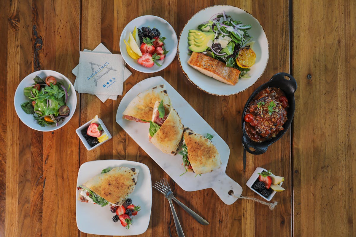 a plate of food with a slice of cake on a wooden table