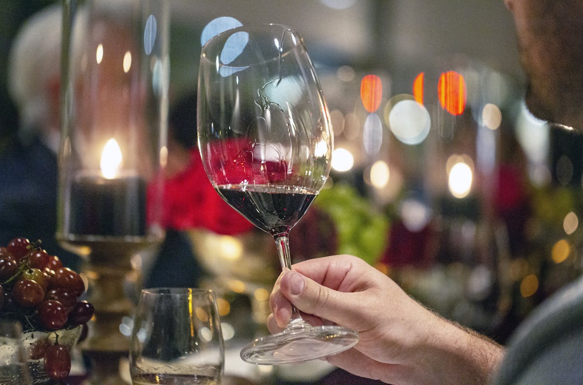 a close up of a person holding a wine glass