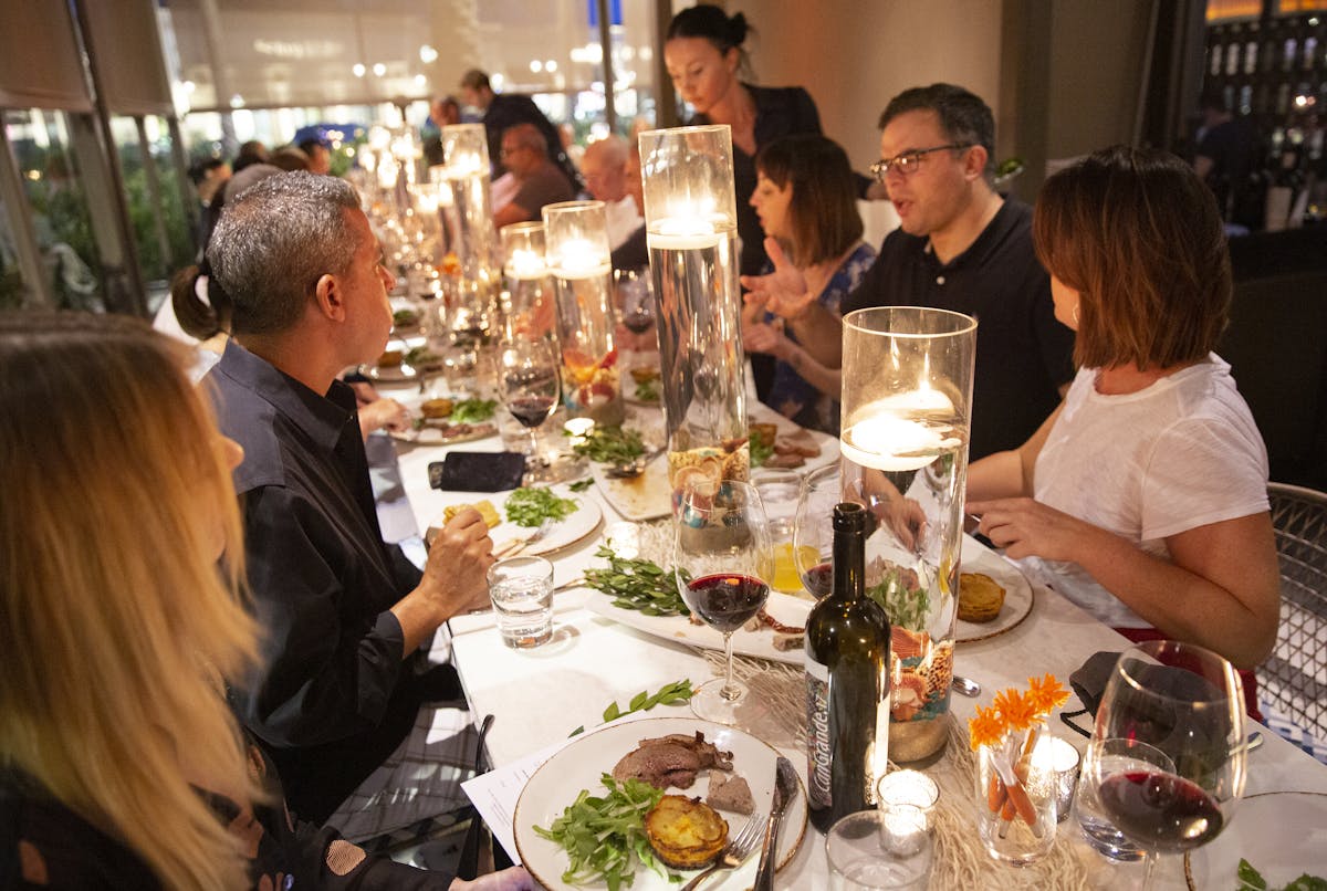 a group of people sitting at a table eating food
