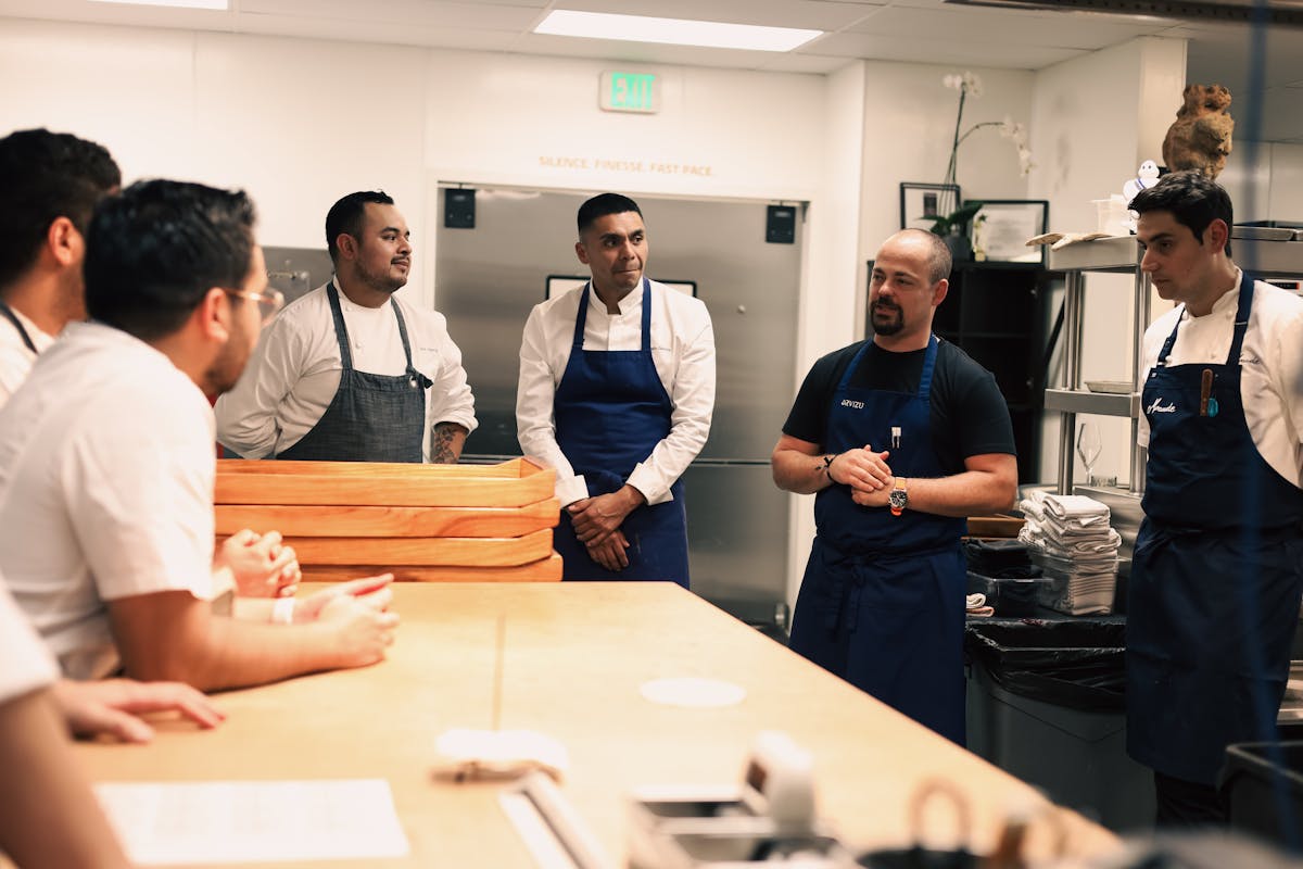 a group of people standing around a table