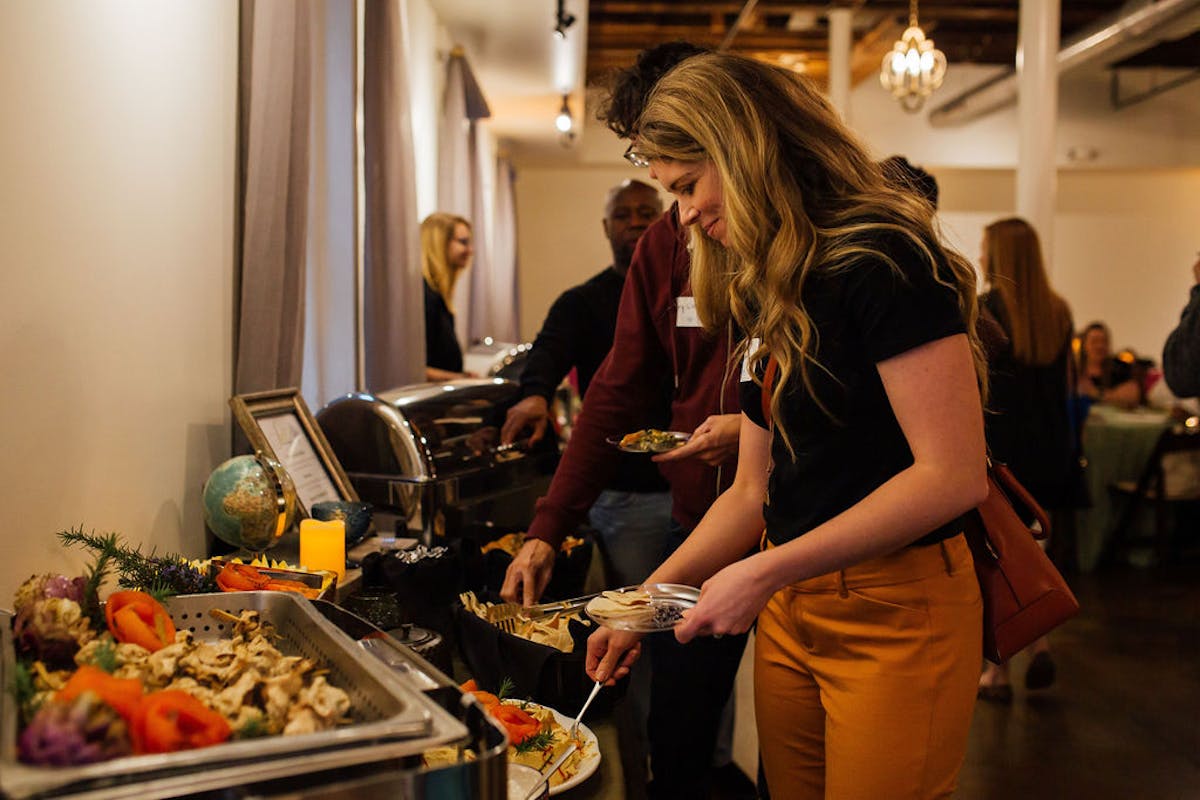 a woman standing in a kitchen preparing food