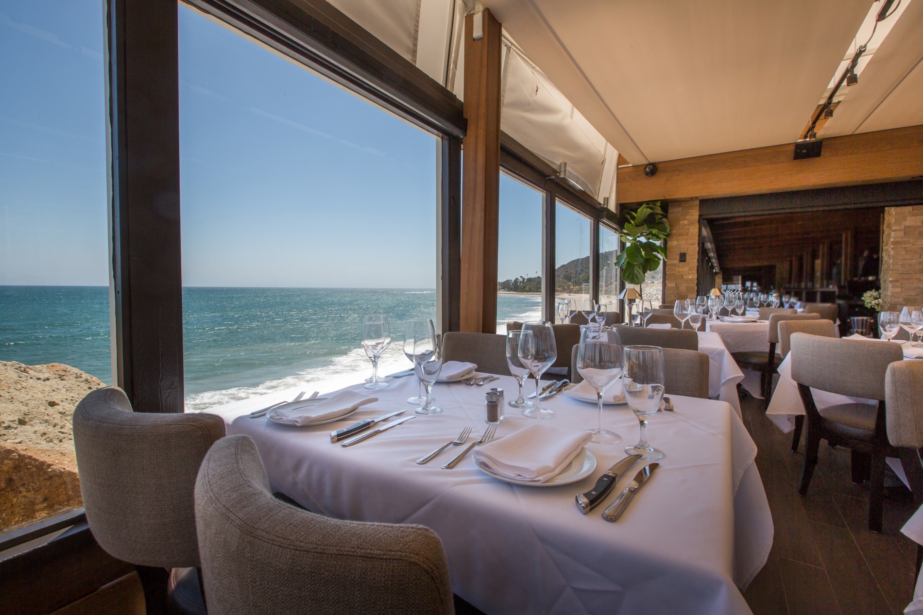a table set for a dinner with a view of the ocean