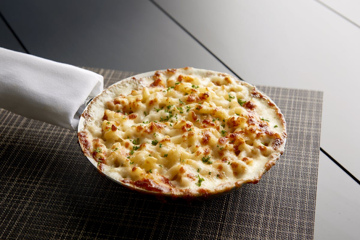 a skillet of mac & cheese sitting on top of a table