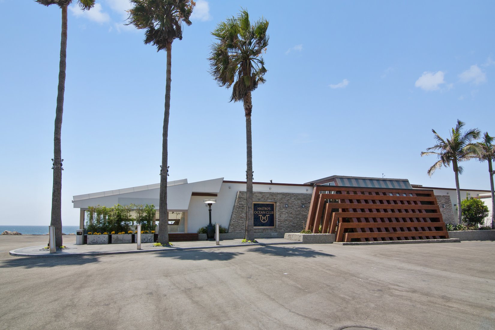 a building with palm trees and a parking lot