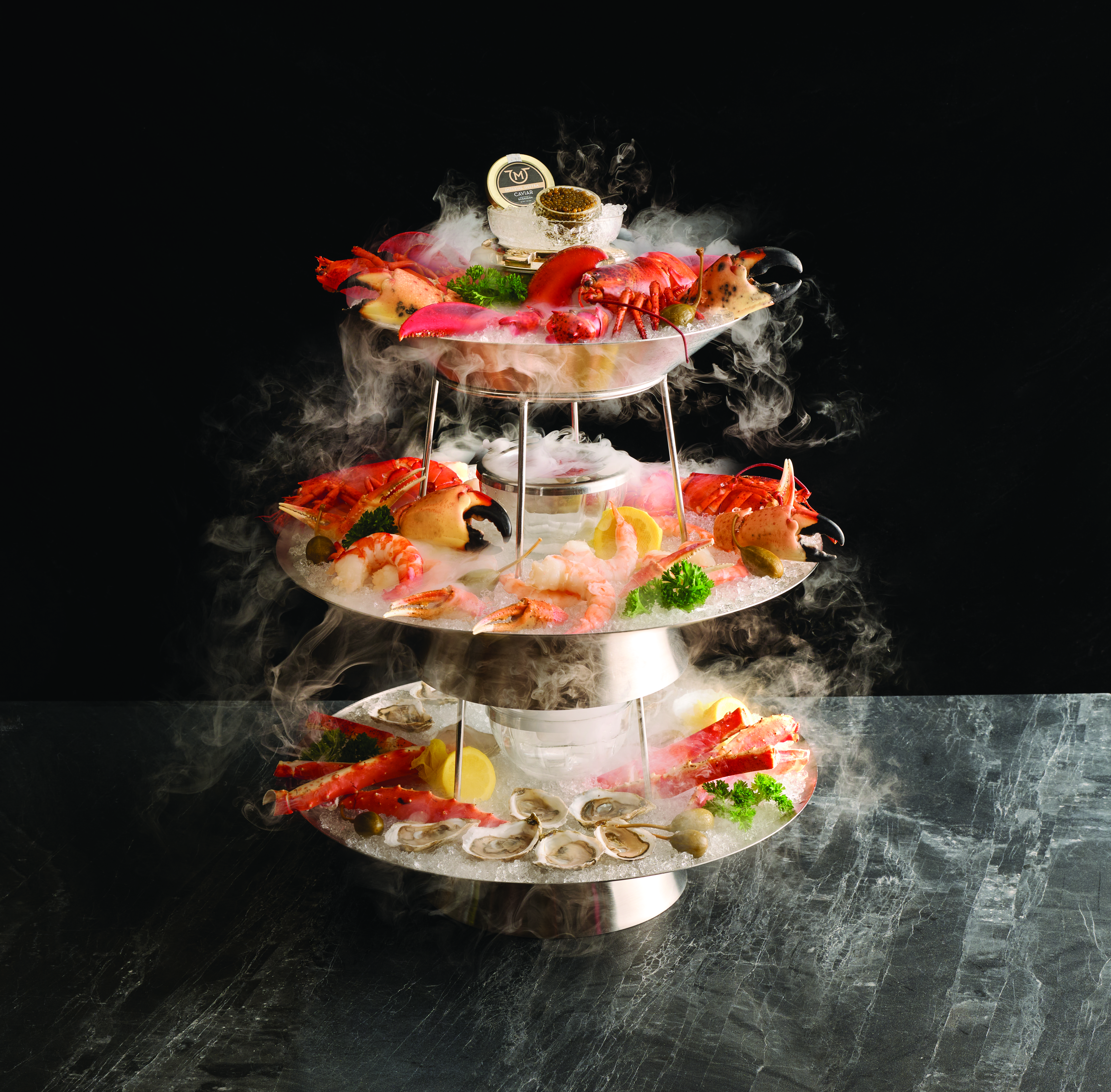 a three tiered tray with seafood on it