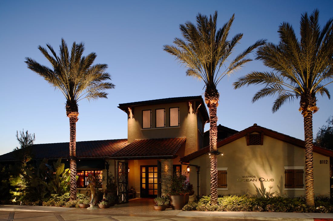 a restaurant building with palm trees