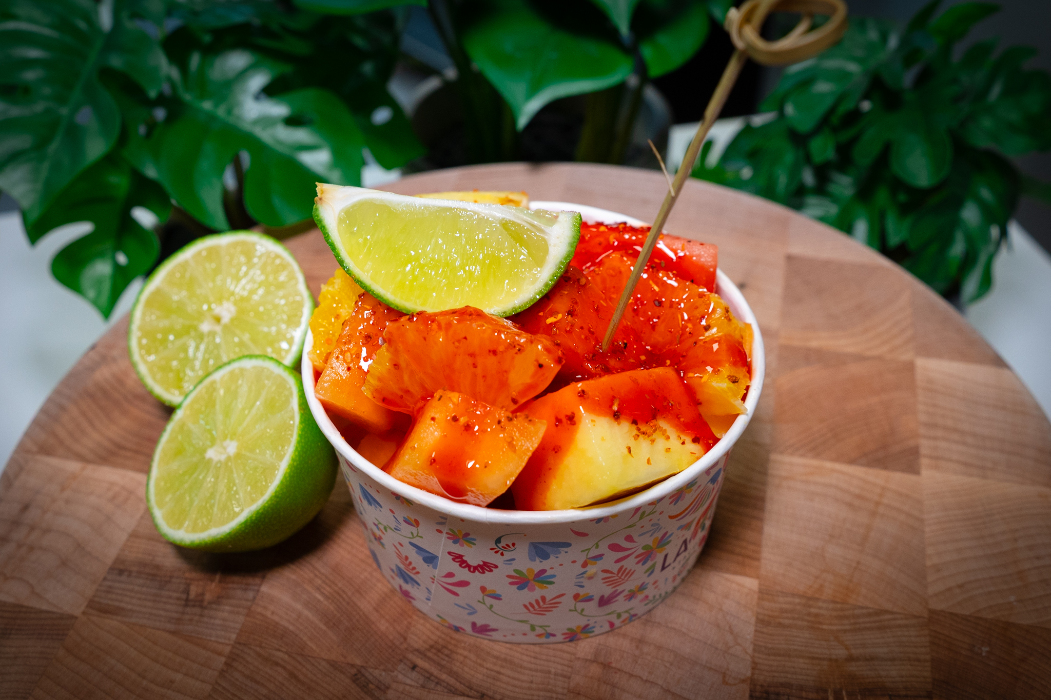 a bowl of fruit sitting on top of a wooden table