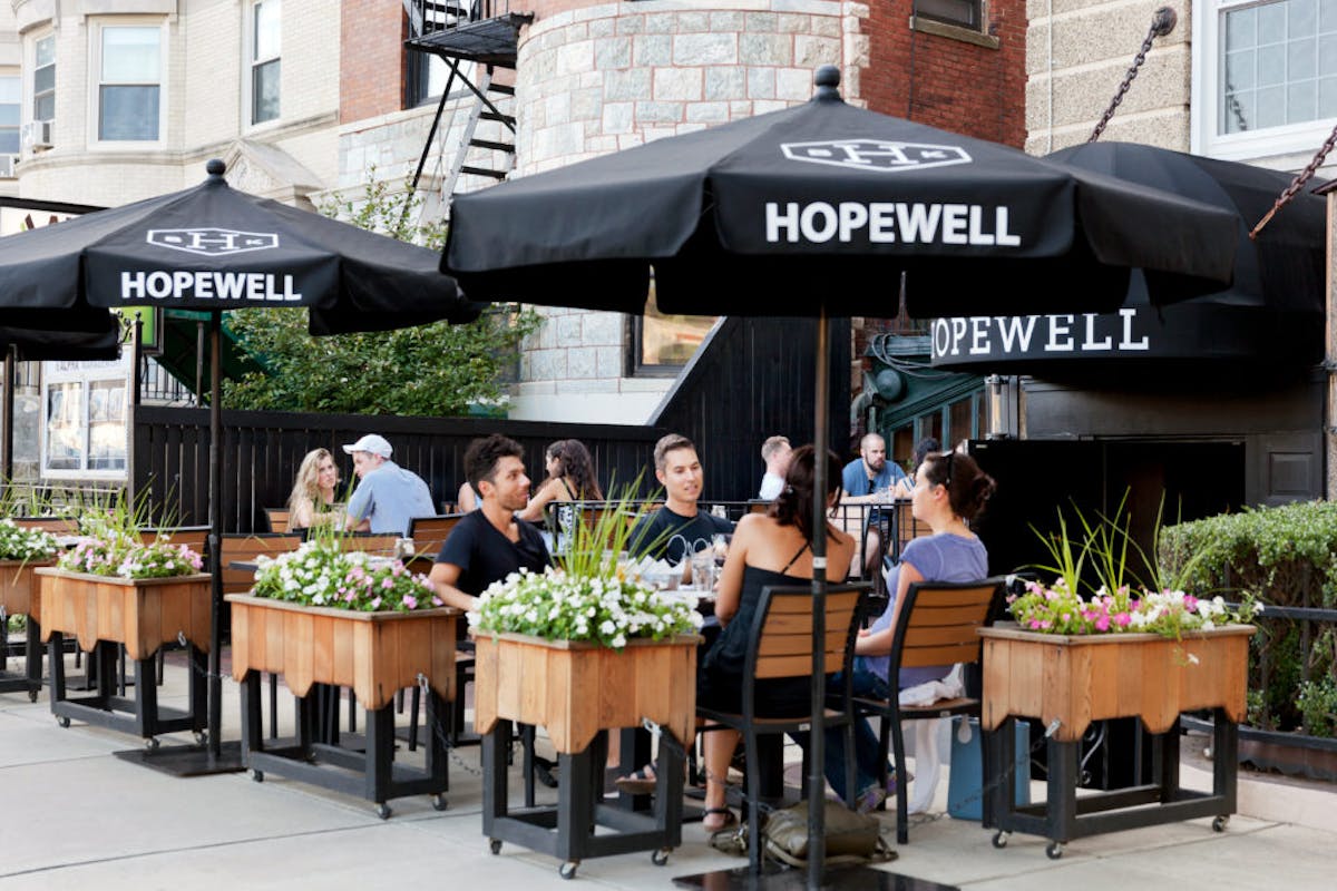 a group of people sitting at a table in front of a building
