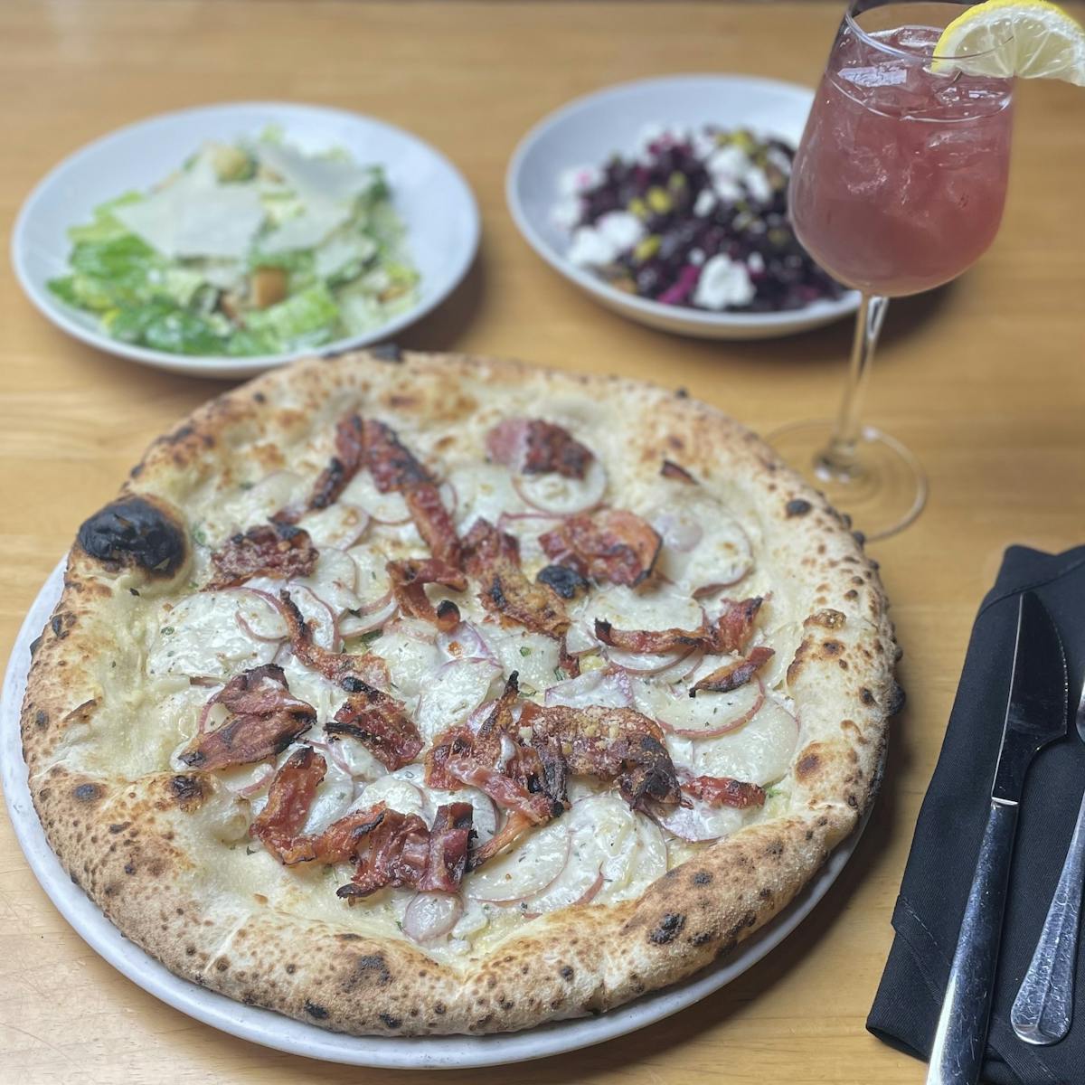 a pizza sitting on top of a wooden table