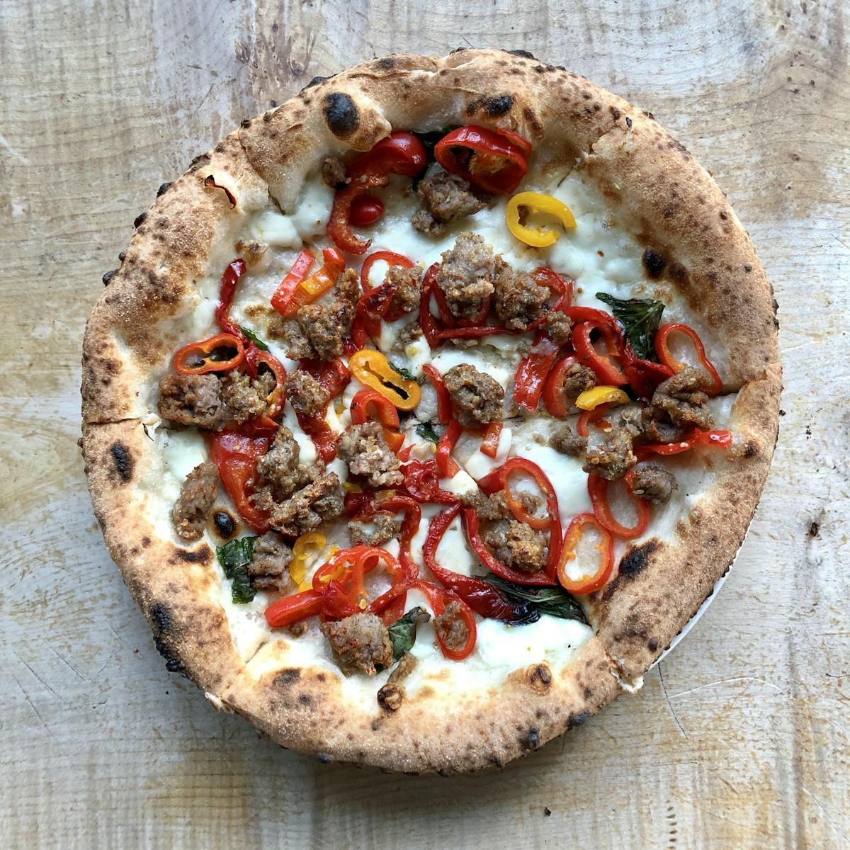 a pizza sitting on top of a wooden cutting board