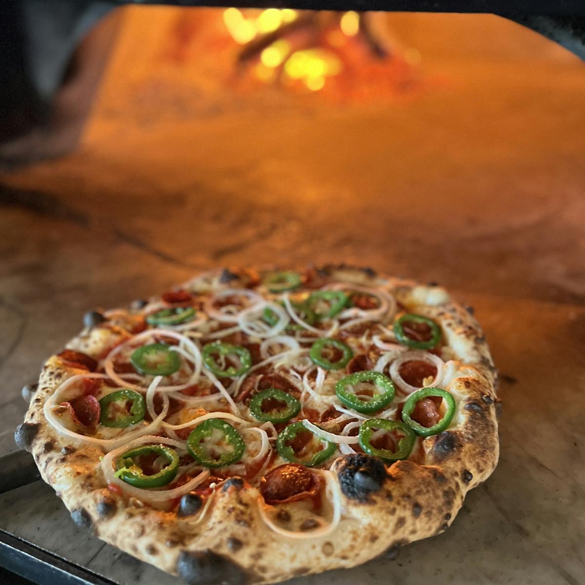 a pizza sitting on top of a wooden cutting board