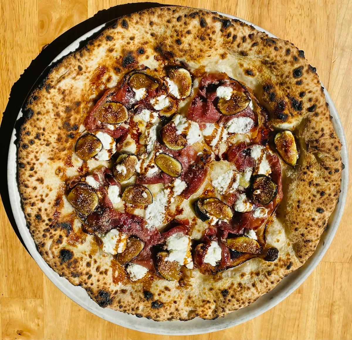 a pizza sitting on top of a wooden table