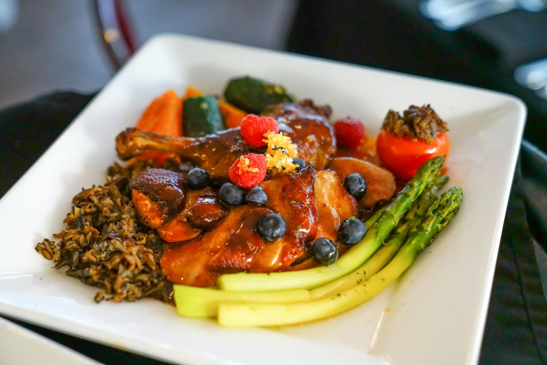 a white palte topped with grilled chicken breast and asparagus