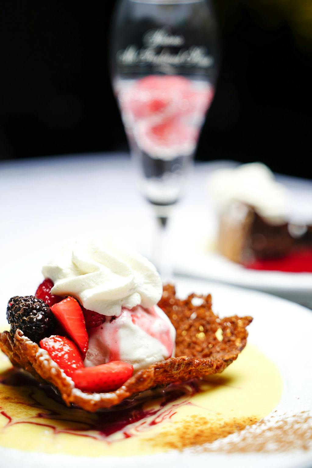 a close up of a chocolate dessert topped with whipped cream and strawberries and blueberries