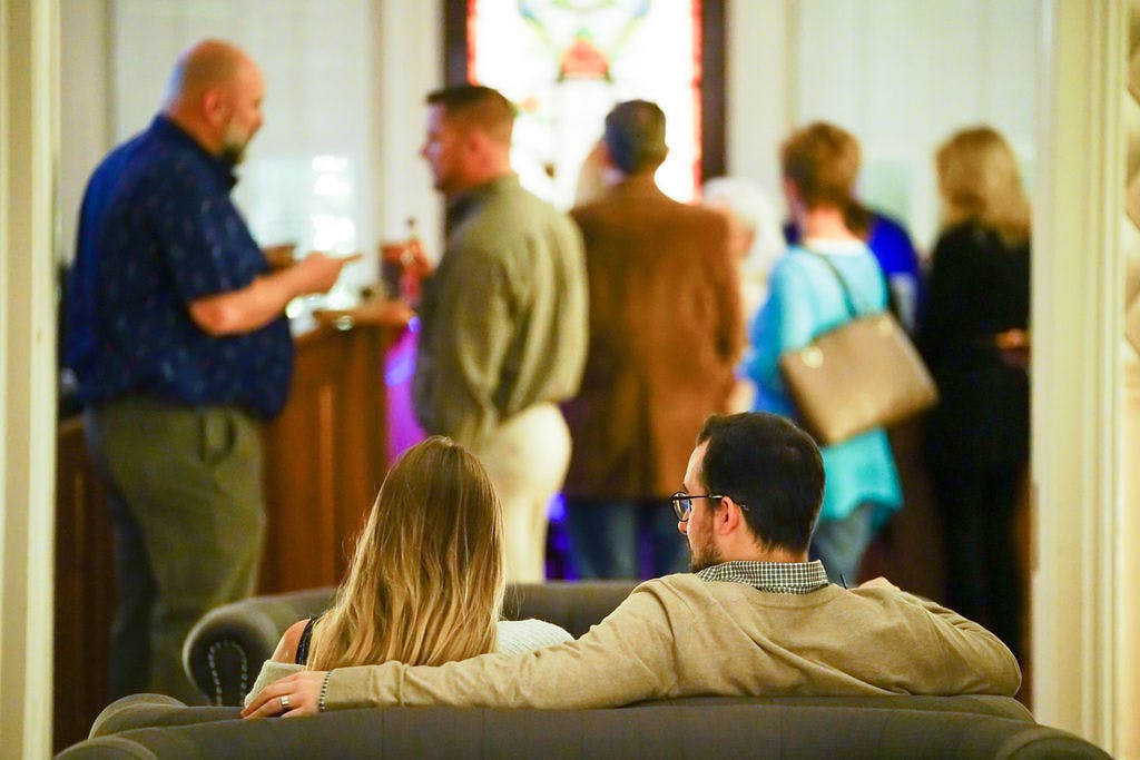 a close up of a couple sitting at a couch while hugging