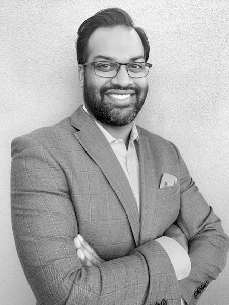 a man wearing glasses posing for the camera