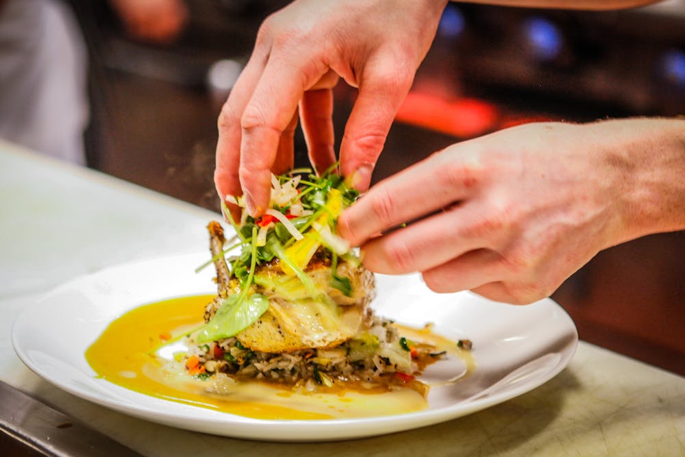 a person cutting a piece of food on a plate