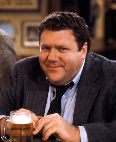 George Wendt sitting at a table