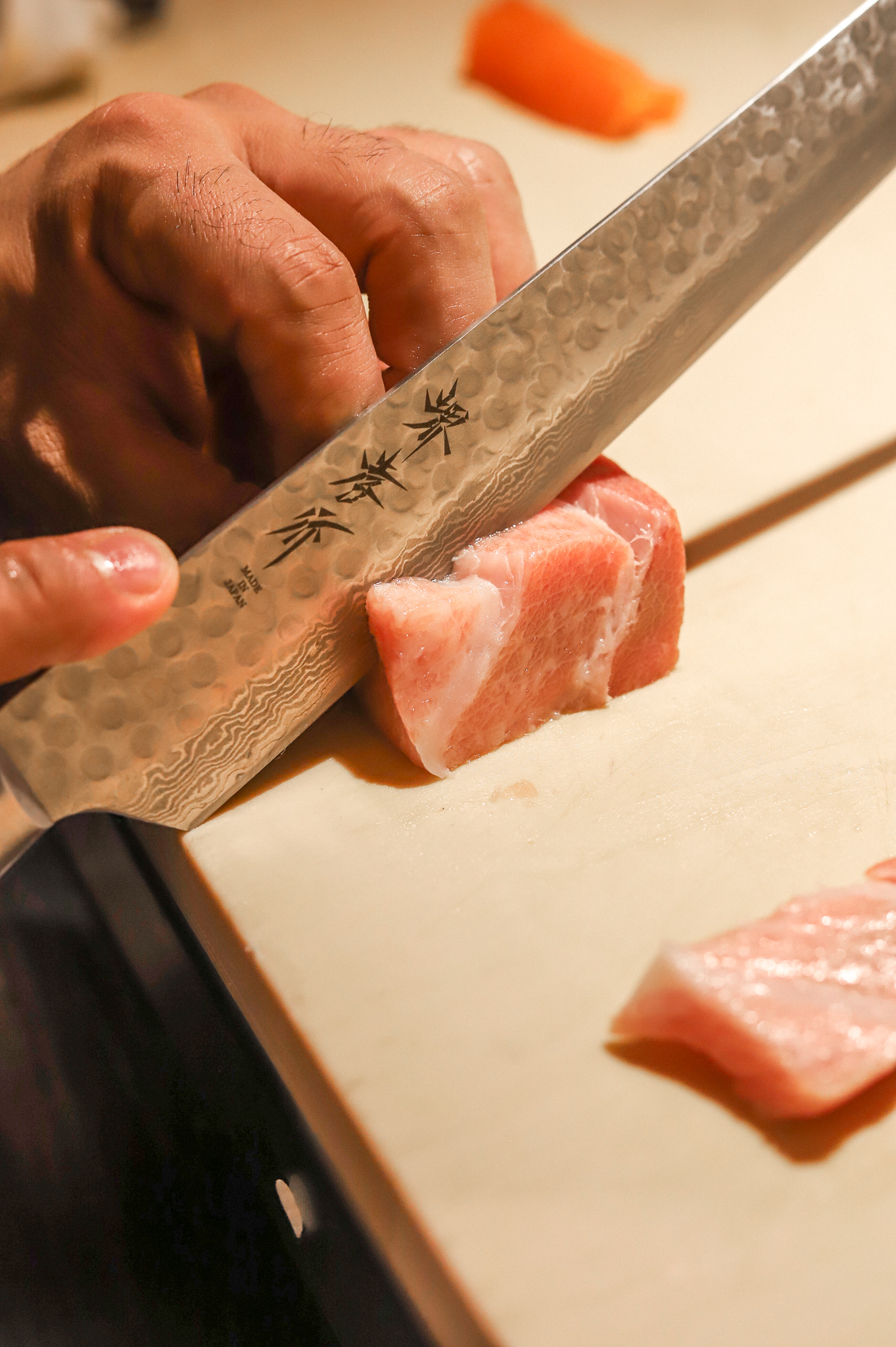a hand holding a fork and knife on a cutting board