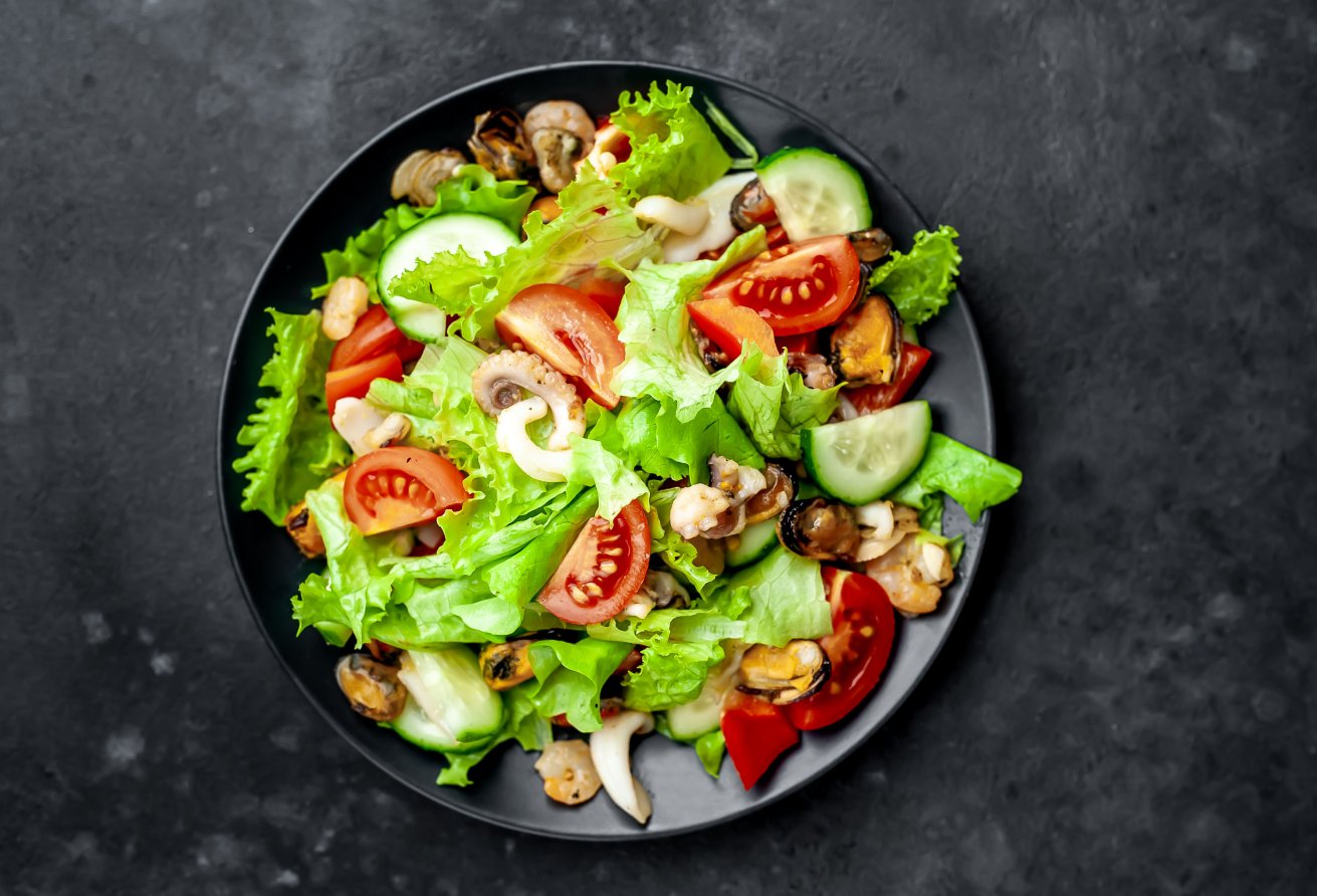 a plate of salad with tomatoes cucumbers and lettuce