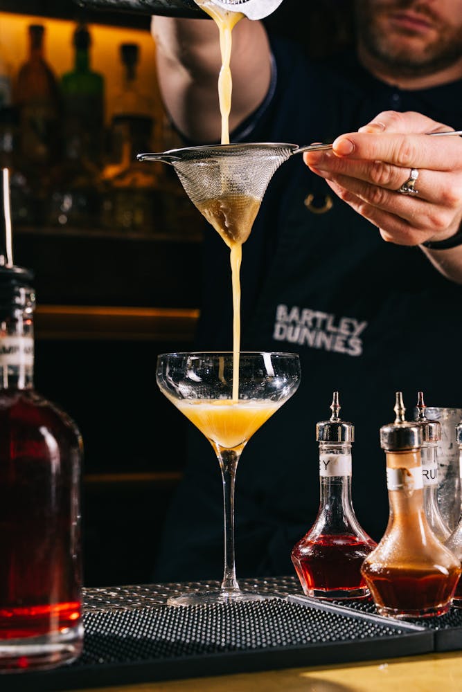 a man sitting at a table with wine glasses