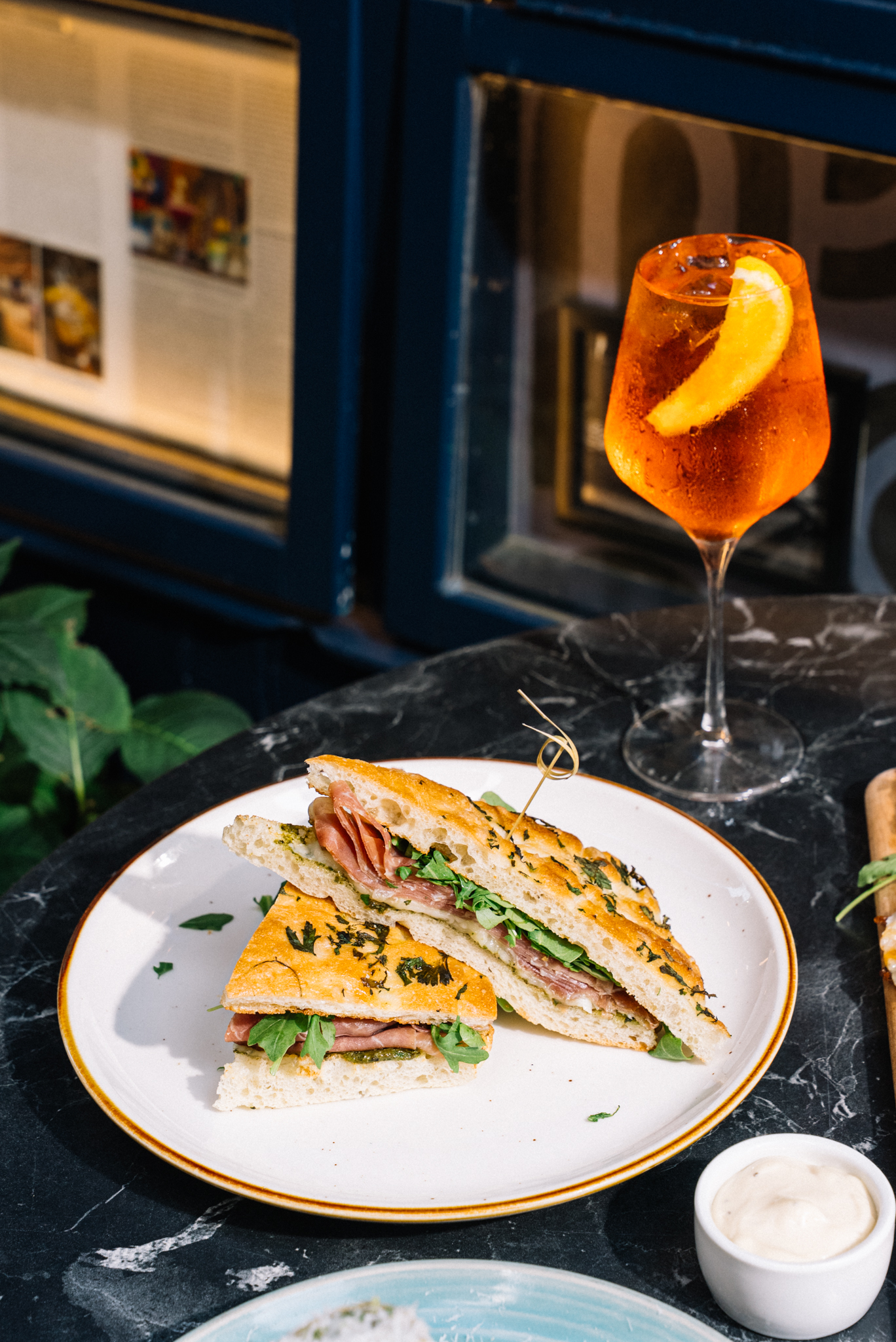 A focaccia sandwich with a drink