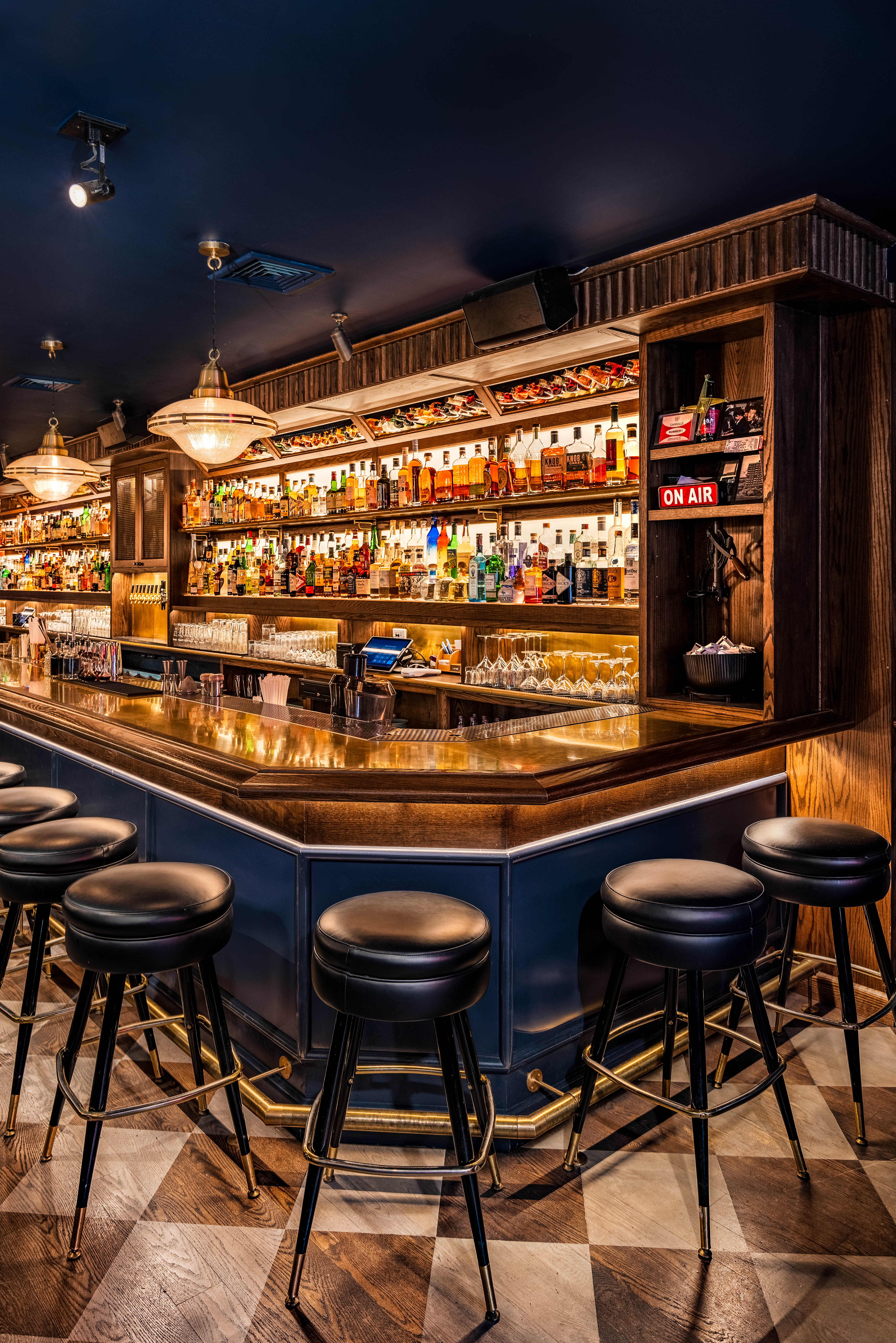 a bar with a row of stools and bottles